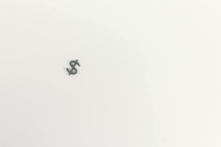Close-up of a dollar symbol on a white background, symbolizing economy.